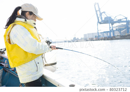 Young woman enjoying sea fishing Young woman enjoying sea fishing 80323712