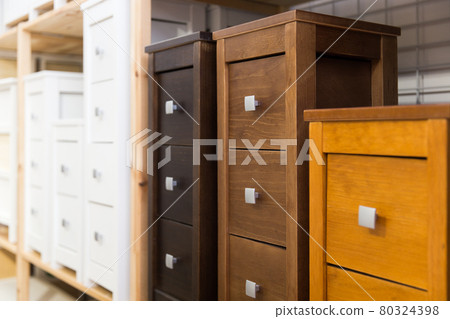 Wooden bedside tables with drawers on shelves of furniture store 80324398