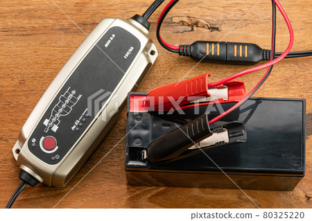 High angle view of battery charger equipment is charging a dry battery. 80325220