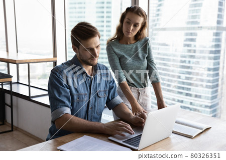 Angry female team leader looking with demand on incompetent employee. Angry female team leader looking with demand on incompetent employee. 80326351