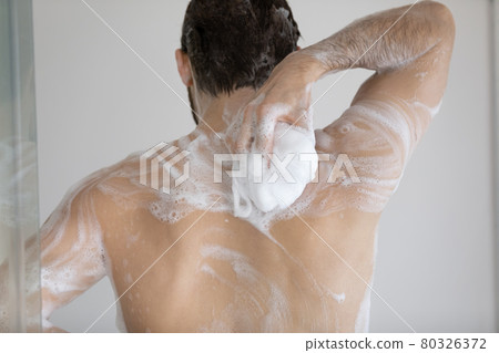 Back of handsome athletic wet young man taking shower 80326372