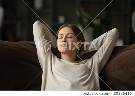 Mindful happy relaxed young woman sleeping on comfortable sofa. 80326416