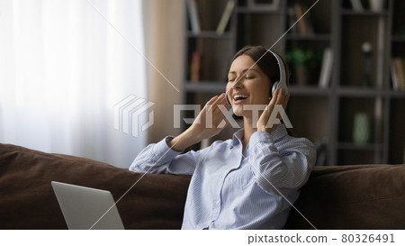 Happy relaxed attractive young woman listening music in headphones. 80326491