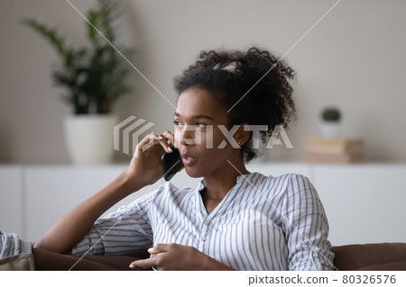 Close up smiling African American woman chatting on phone Close up smiling African American woman chatting on phone 80326576