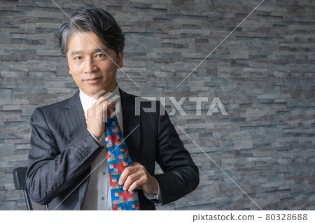 Portrait of a middle-aged man retiring his tie 80328688