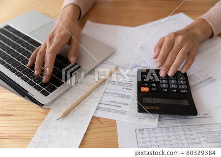 Close up young woman calculating financial expenditures. Close up young woman calculating financial expenditures. 80329384