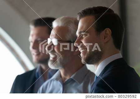 Happy young male business leader looking away and smiling Happy young male business leader looking away and smiling 80329592