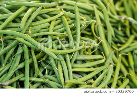 Pile green string beans displayed on food market. Abstract healthy nutrition background - shallow depth of field photo, only few hulls in focus 80329700