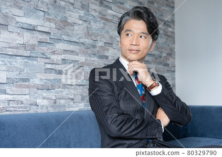 Portrait of a middle-aged man sitting on the couch Portrait of a middle-aged man sitting on the couch 80329790