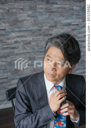Portrait of a middle-aged man retiring his tie Portrait of a middle-aged man retiring his tie 80329982