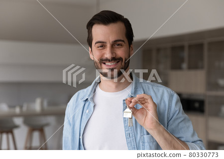 Head shot portrait of smiling man holding keys, purchasing house Head shot portrait of smiling man holding keys, purchasing house 80330773