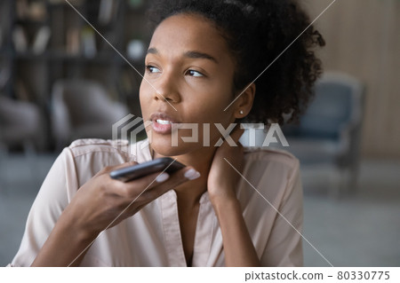 Close up smiling African American woman recording audio message Close up smiling African American woman recording audio message 80330775