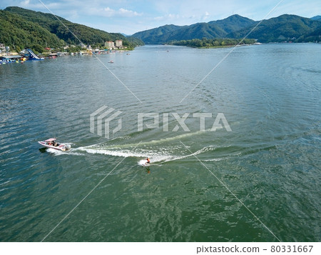 在涼爽的北漢江上享受滑水和划船的人們。 在涼爽的北漢江上享受滑水和划船的人們。 80331667