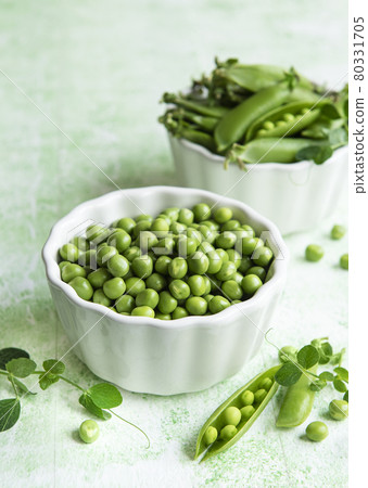 Fresh green peas pods and green peas with sprouts on green wooden background. Fresh green peas pods and green peas with sprouts on green wooden background. 80331705