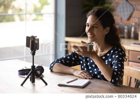 Happy Hispanic blogger girl taking video on mobile phone 80334024