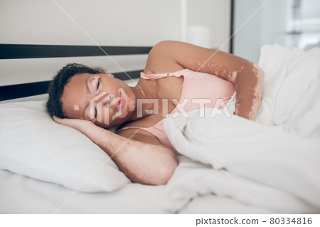 Young woman lying in bed and feeling peaceful Young woman lying in bed and feeling peaceful 80334816