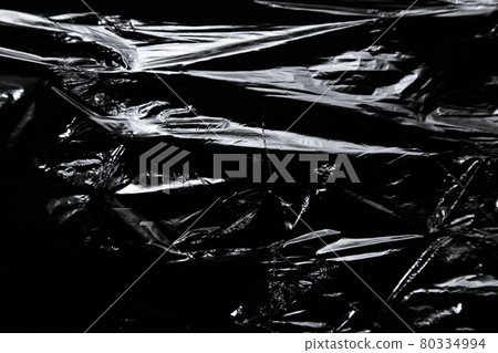 Photo of the polyethylene surface with ragged hole on black background 80334994
