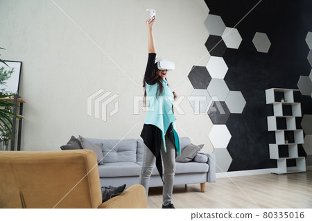 Woman with virtual reality headset is playing game. Woman with virtual reality headset is playing game. 80335016