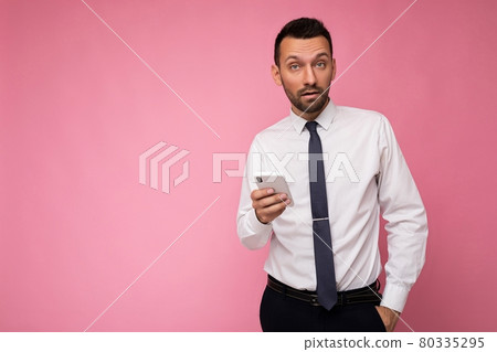 Photo of handsome good looking man wearing casual white shirt and tie isolated on pink background 80335295