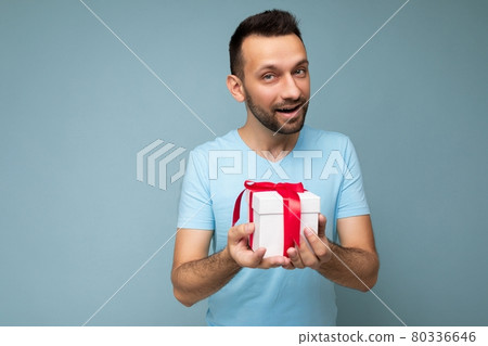 Photo shot of handsome positive brunette unshaven young man isolated over blue background wall 80336646