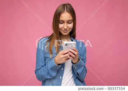 Beautiful young woman wearing casual clothes standing isolated over background surfing on the Beautiful young woman wearing casual clothes standing isolated over background surfing on the 80337334