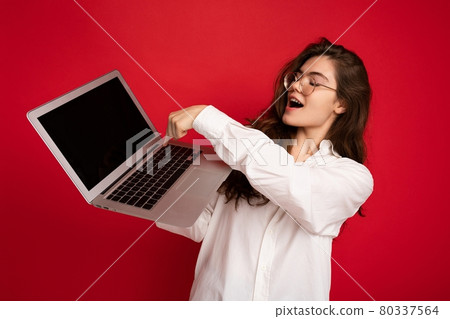 Close-up portrait of overjoyed Beautiful smiling happy young woman holding computer laptop looking 80337564