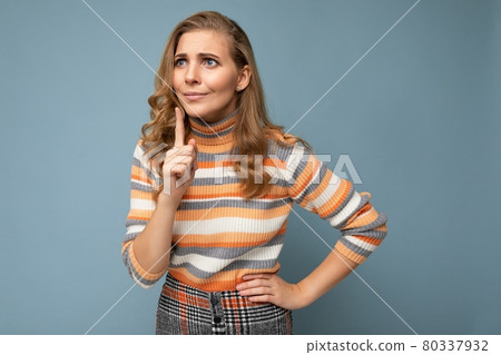 Portrait of young blonde beautiful curly woman with sincere emotions wearing striped sweater 80337932