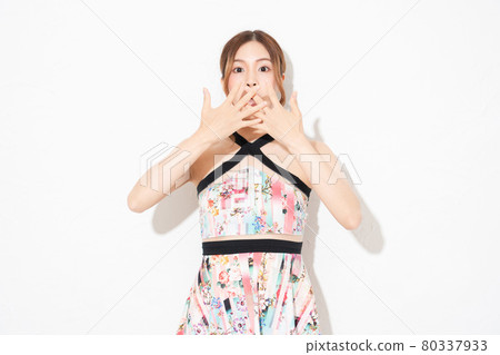 A young woman in a one-piece, standing in front of a white wall and making a surprise gesture A young woman in a one-piece, standing in front of a white wall and making a surprise gesture 80337933