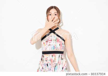 A young woman in a one-piece, standing in front of a white wall and making a surprise gesture A young woman in a one-piece, standing in front of a white wall and making a surprise gesture 80337934