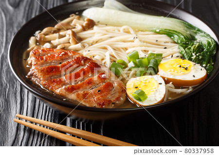 Ramen soup with duck, noodles, egg and pak choi in bowl on table close up. horizontal Ramen soup with duck, noodles, egg and pak choi in bowl on table close up. horizontal 80337958