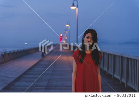 黃昏時分在海裡穿紅色連體衣的女人 黃昏時分在海裡穿紅色連體衣的女人 80338011