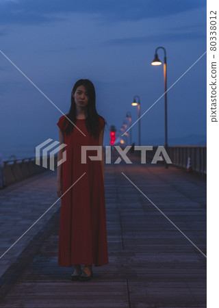 黃昏時分在海裡穿紅色連體衣的女人 黃昏時分在海裡穿紅色連體衣的女人 80338012