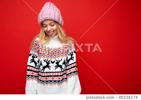 Photo of pretty positive smiling young blonde woman isolated over red background wall wearing winter 80338174