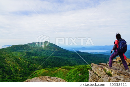 Climbers looking at Mt. Akita Komagatake and Lake Tazawa from the summit of Mt. Climbers looking at Mt. Akita Komagatake and Lake Tazawa from the summit of Mt. 80338511