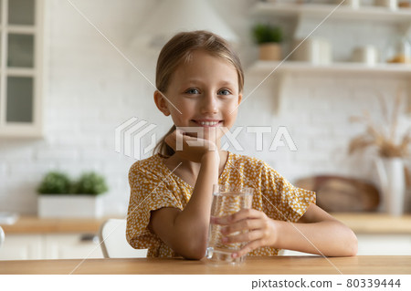 Portrait of adorable small kid girl with glass of water. 80339444