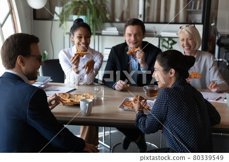 Happy diverse coworkers enjoying pizza party at office meeting table Happy diverse coworkers enjoying pizza party at office meeting table 80339549