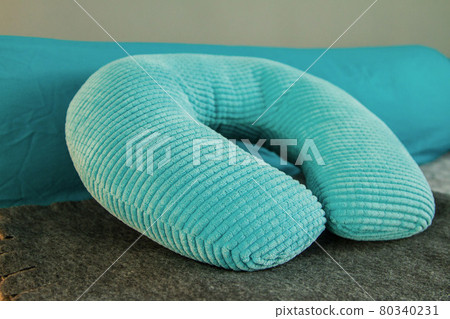 Turquoise orthopedic bright soft travel neck pillow on the bed Turquoise orthopedic bright soft travel neck pillow on the bed 80340231