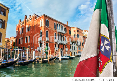 Italian maritime flag and Venetian Renaissance waterfront palaces, gondola stations, Venice, Italy. Travel destinations, UNESCO world heritage  80340553