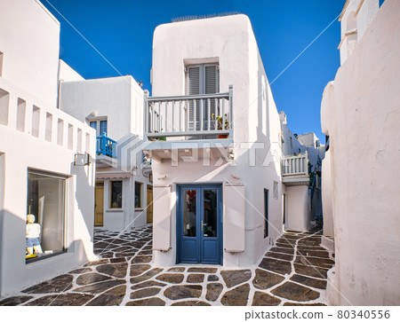 Traditional narrow cobbled streets, beautiful alleyways of Greek island town. Whitewashed houses, shop, cafe, morning summer sunshine. Mykonos, Greece 80340556