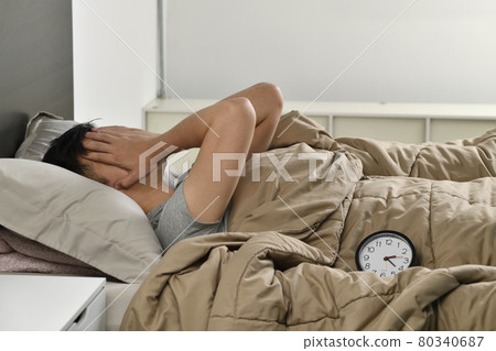 Depressed young Asian man lying in bed cannot sleep from insomnia Depressed young Asian man lying in bed cannot sleep from insomnia 80340687