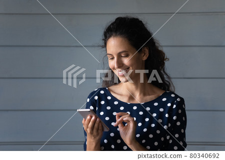 Happy pretty Latin woman reading message on mobile phone 80340692