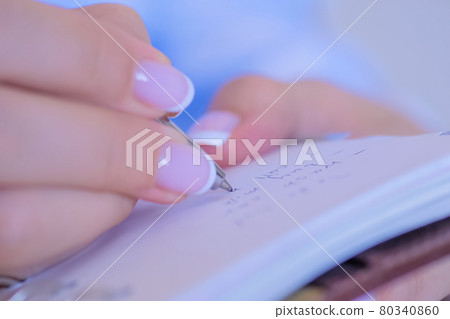 Woman hand holding pen and writing to do list in vintage notebook organizer Woman hand holding pen and writing to do list in vintage notebook organizer 80340860