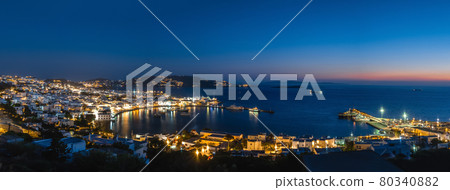 Beautiful night panorama of Mykonos, Greece, ships, port, whitewashed houses. Town lights up. Vacations, leisure, nightlife, Mediterranean lifestyle Beautiful night panorama of Mykonos, Greece, ships, port, whitewashed houses. Town lights up. Vacations, leisure, nightlife, Mediterranean lifestyle 80340882