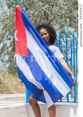 Vertical photo of a latina woman showing a cuban flag 80343417