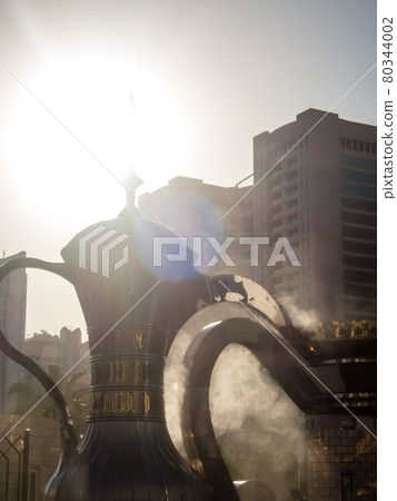 In the city of Abu Dhabi, a large Arabian teapot object placed in a park under the bright sun In the city of Abu Dhabi, a large Arabian teapot object placed in a park under the bright sun 80344002