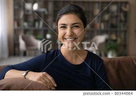 Portrait of smiling Indian female renter relax at home 80344064