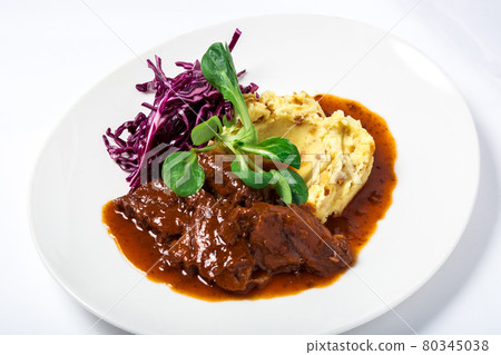 Veal cheeks in gravy with potatoes and cabbage, decorated herbs Veal cheeks in gravy with potatoes and cabbage, decorated herbs 80345038