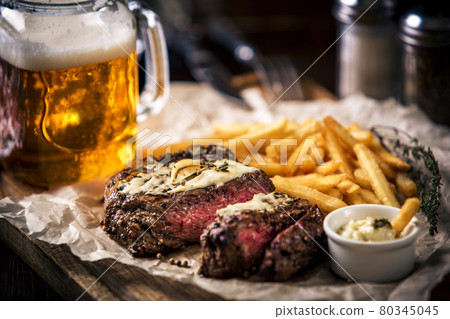 Healthy lean grilled medium-rare steak with french fries, beer 80345045