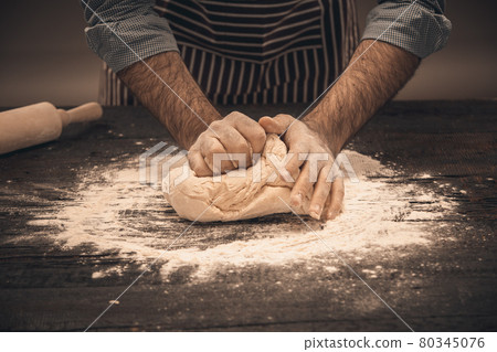 Male hands knead the dough. Male hands knead the dough. 80345076