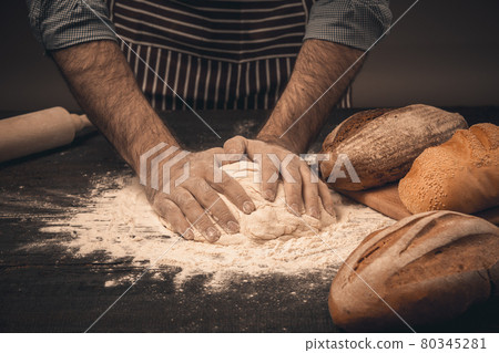 Male hands knead the dough. 80345281